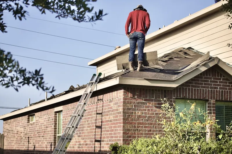 Professional roofer working on a residential roof in Watson Village